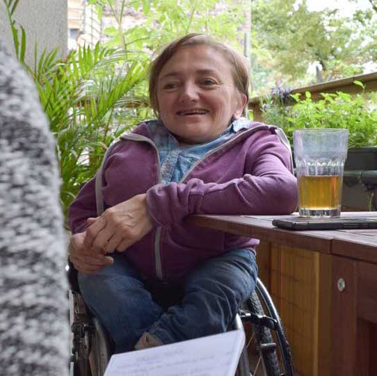 Rebecca Maskos sitzt mit einem Tee an ihrem Balkontisch