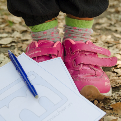 Ein Schreibblog mit Stift liegt an Kinderschuhen