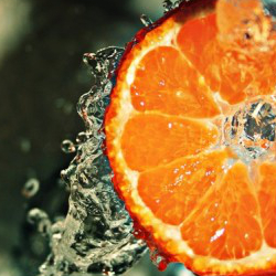 Eine Orangenscheibe umgeben von Wassertropfen