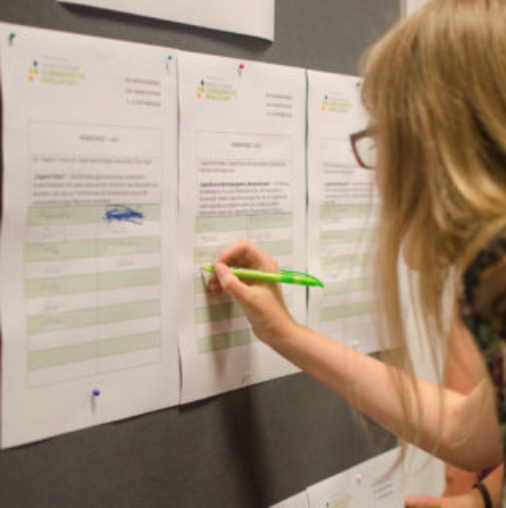 Eine Teilnehmerin sucht sich ihre Workshops für das Wochenende aus.