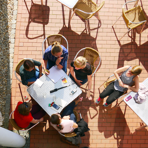 Pięć osób siedzących dookoła stołu – widok z góry