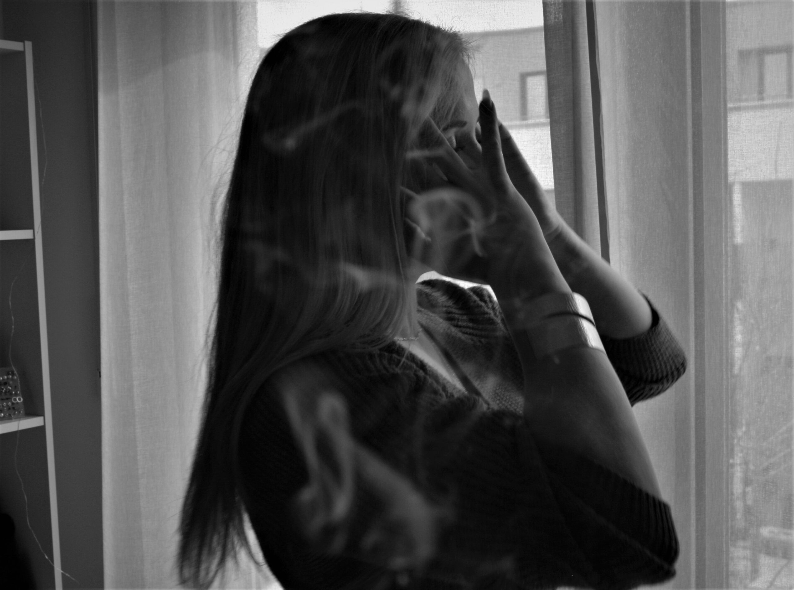 eine junge Frau steht vor einem Fenster