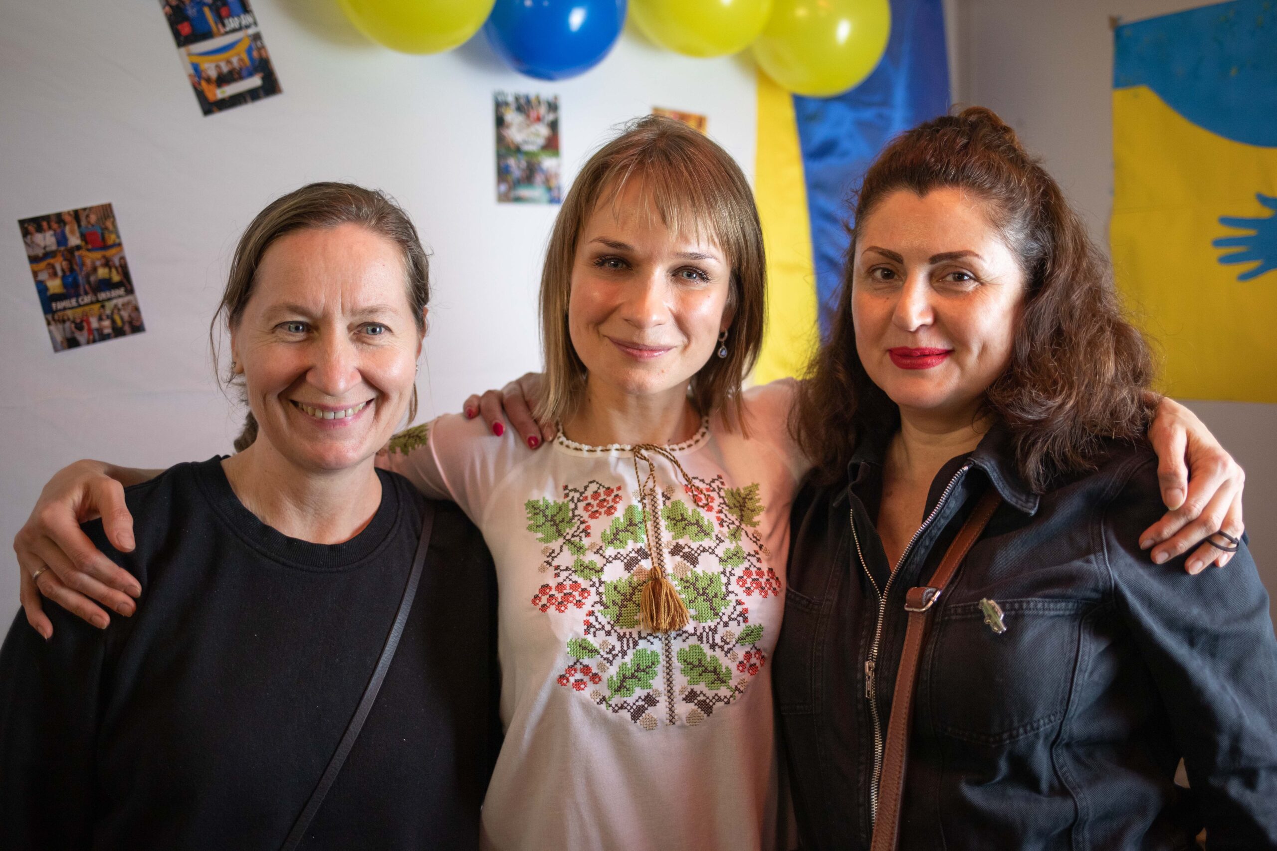 Es sind drei Frauen zu erkennen die lächeln.